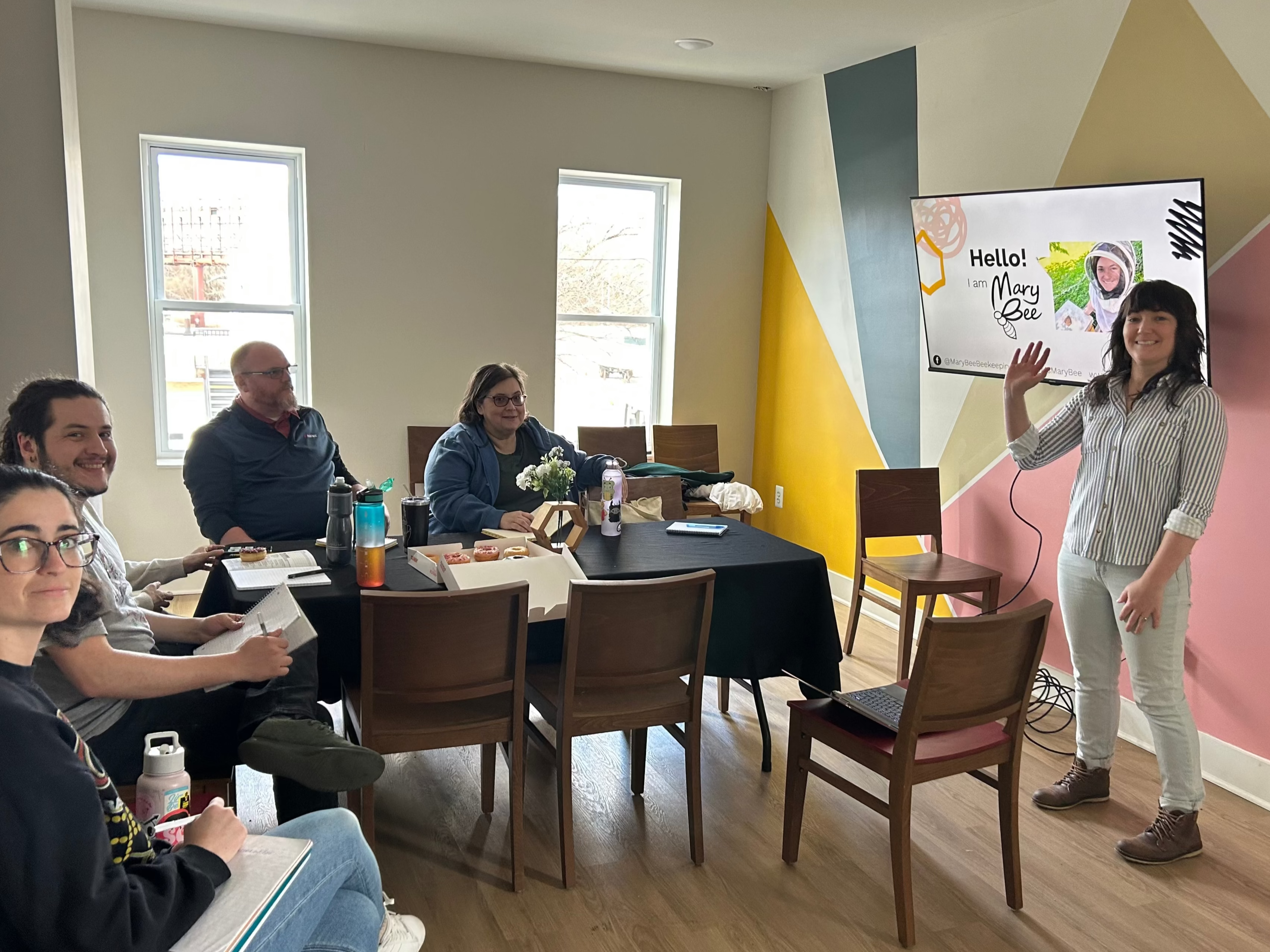 Mary Bee leads a presentation for a small group.